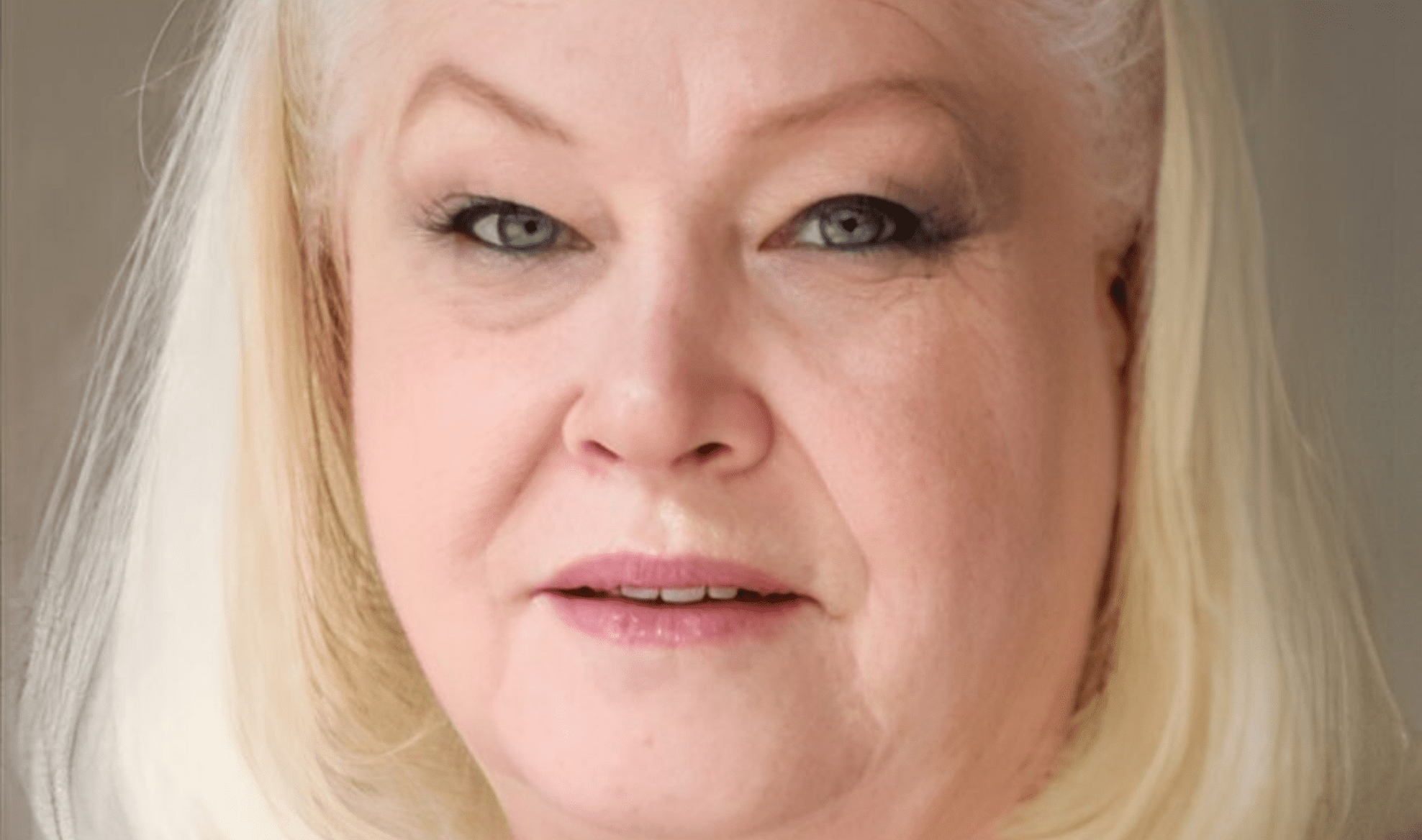 A woman with blonde hair and blue eyes.