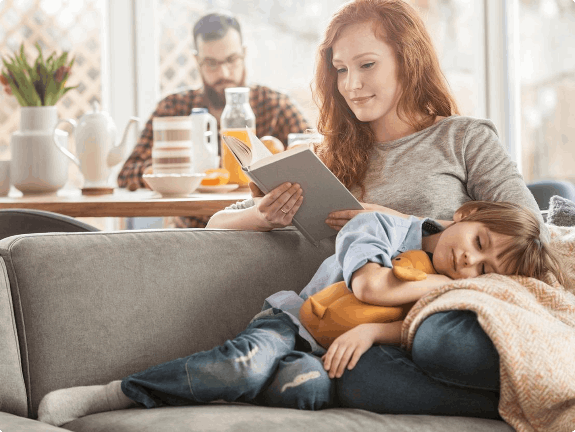 jpeg-optimizer_Frame 1618874330 (4) A woman and child sitting on the couch reading.