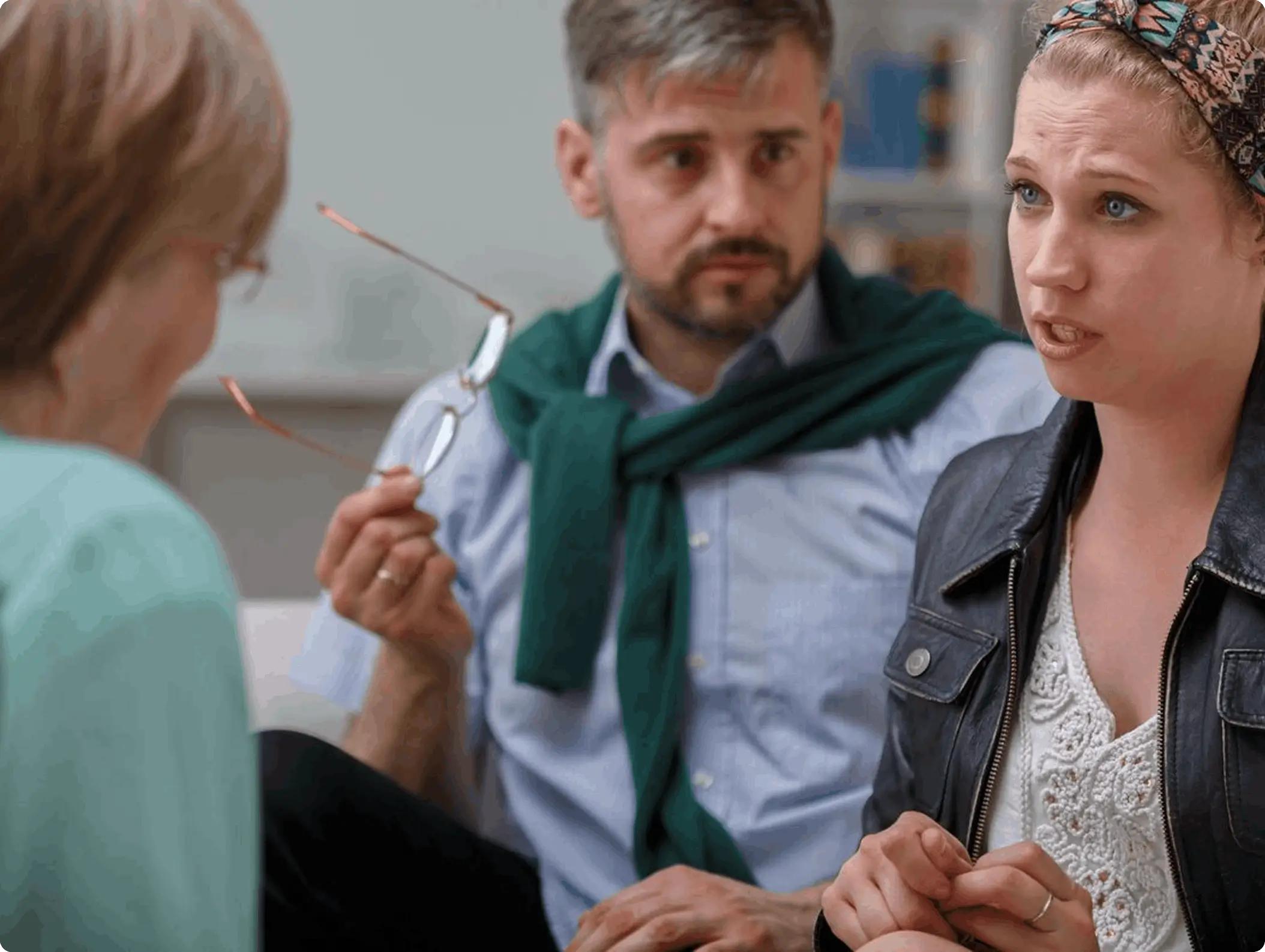 A man and woman talking to another person.